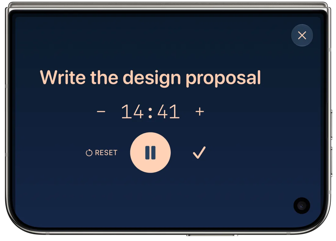 A Solarday Focus timer on the cover display of a closed iPhone Duo, turned on its side. The Do, Write the design proposal, sits above 14:41 remaining, with minus and plus buttons, Reset, Pause and a check mark to complete it.